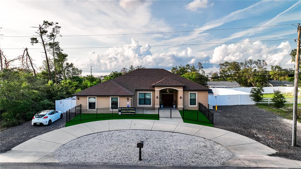 Undisclosed Address Spring Hill, FL 34608 - Photo 2 of 39 a front view of a house with a garden
