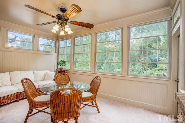 a dining room with furniture a chandelier and a large window