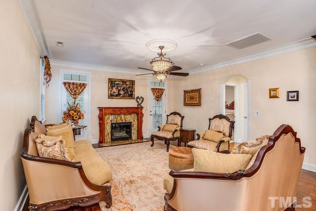 a living room with furniture a fireplace and chandelier