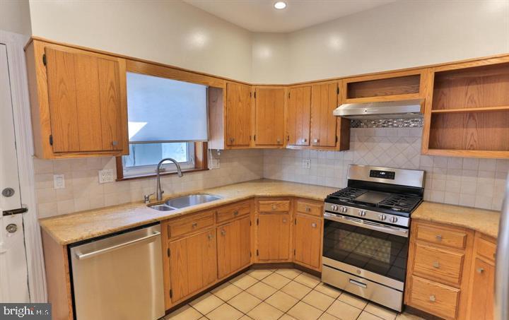 855 North 24th Street Philadelphia, PA 19130 - Photo 11 of 35 a kitchen with stainless steel appliances a stove sink and cabinets