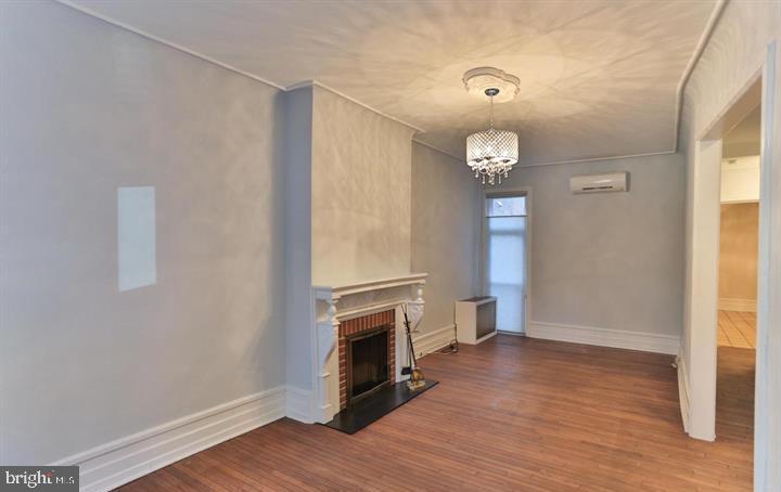 855 North 24th Street Philadelphia, PA 19130 - Photo 8 of 35 a view of an empty room with wooden floor a fireplace and a window