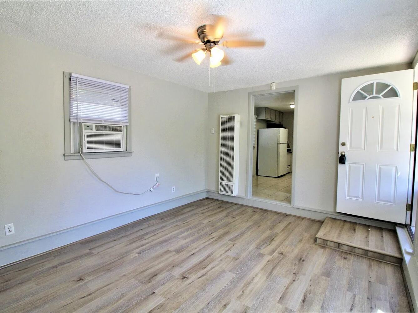 2216 30th Street, Unit REAR Lubbock, TX 79411 - Photo 5 of 14 wooden floor in an empty room with a window