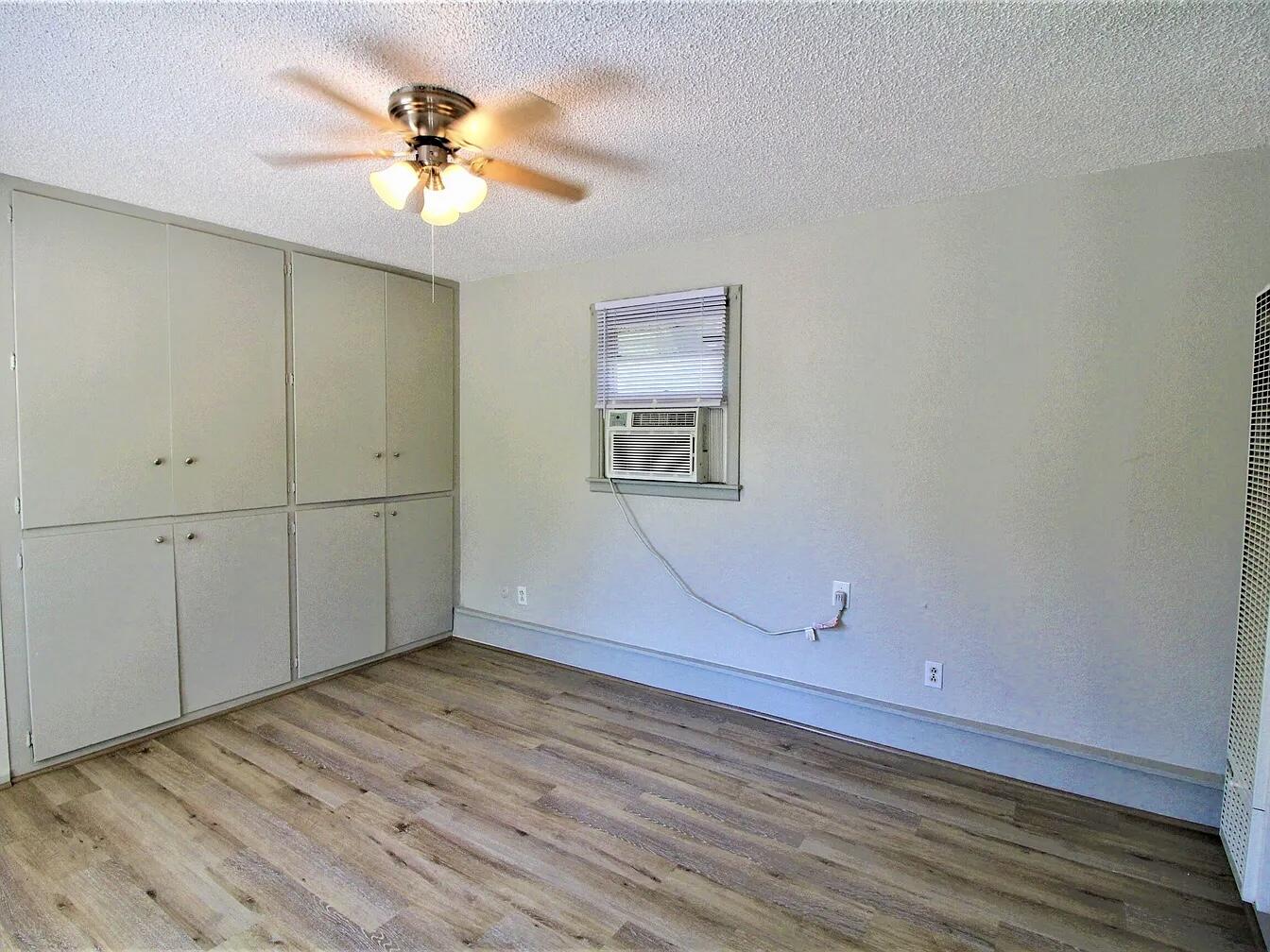 2216 30th Street, Unit REAR Lubbock, TX 79411 - Photo 6 of 14 wooden floor in an empty room with a window
