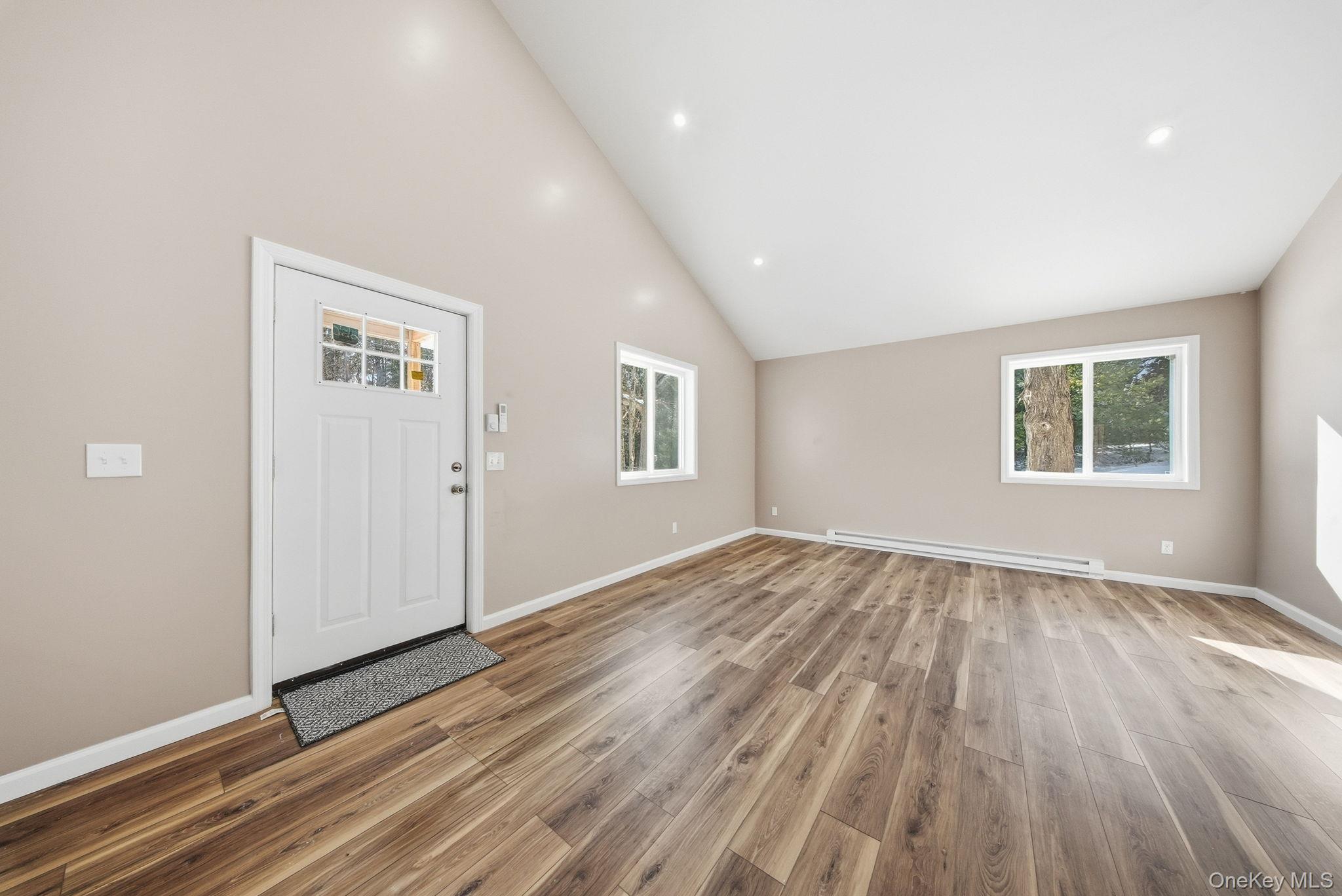 943 State Rte 55 Eldred, NY 12732 - Photo 7 of 33 an empty room with wooden floor and windows