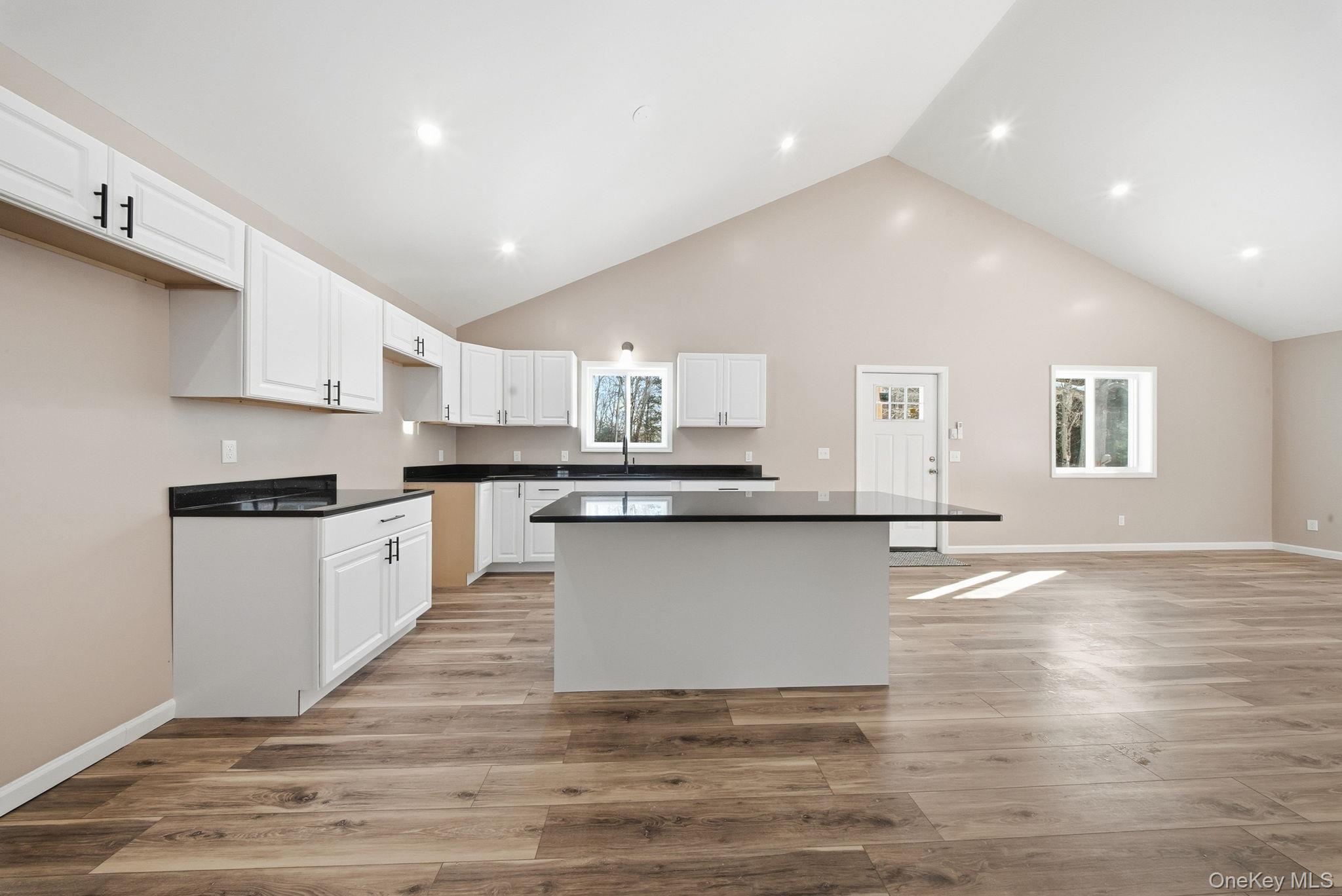943 State Rte 55 Eldred, NY 12732 - Photo 9 of 33 a large kitchen with granite countertop a stove top oven a sink dishwasher and white cabinets with wooden floor