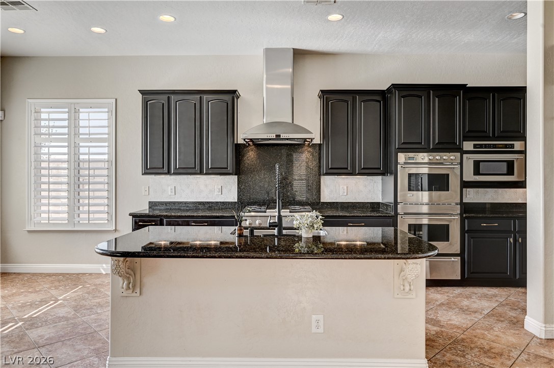 2793 Rosenhearty Drive Henderson, NV 89044 - Photo 9 of 85 This kitchen showcases a functional layout with dark cabinetry and ample counter space.