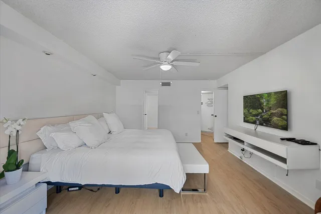 a spacious bedroom with a bed and a flat screen tv