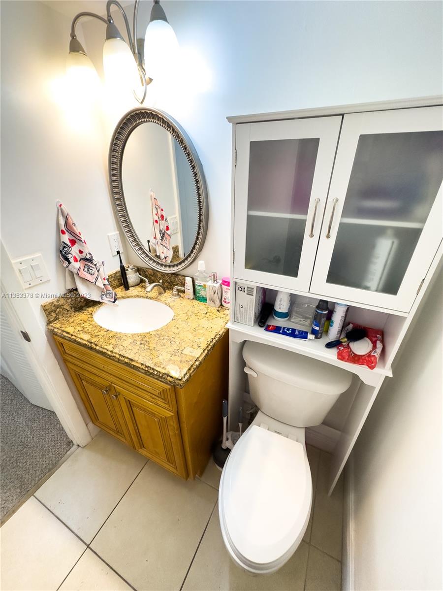 5654 Rock Island Road, Unit 234 Tamarac, FL 33319 - Photo 9 of 10 a bathroom with a toilet mirror and tub