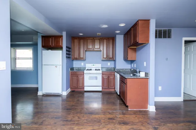 a kitchen with stainless steel appliances granite countertop a refrigerator sink and stove