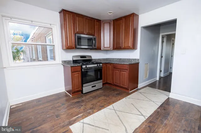 a kitchen with stainless steel appliances granite countertop a stove a sink and a microwave