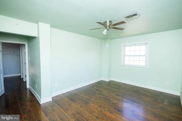 a view of empty room with wooden floor