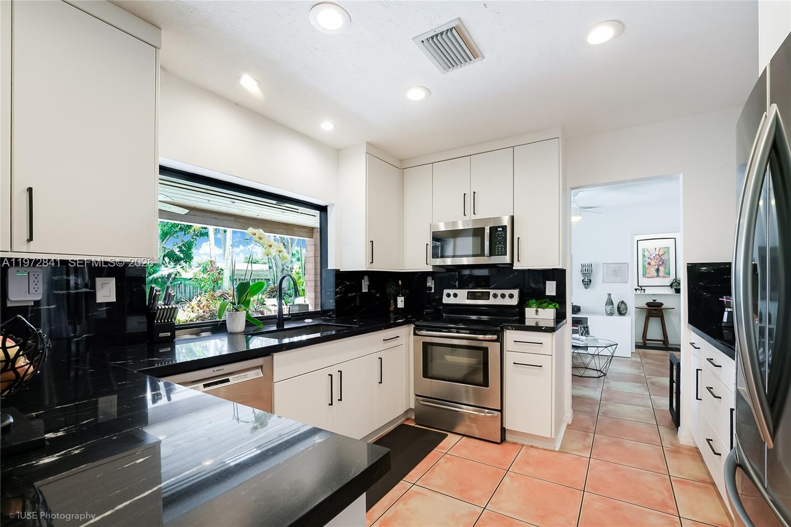 9860 Southwest 122nd Street Miami, FL 33176 - Photo 11 of 27 a kitchen with stainless steel appliances granite countertop a stove top oven a sink a counter space and cabinets