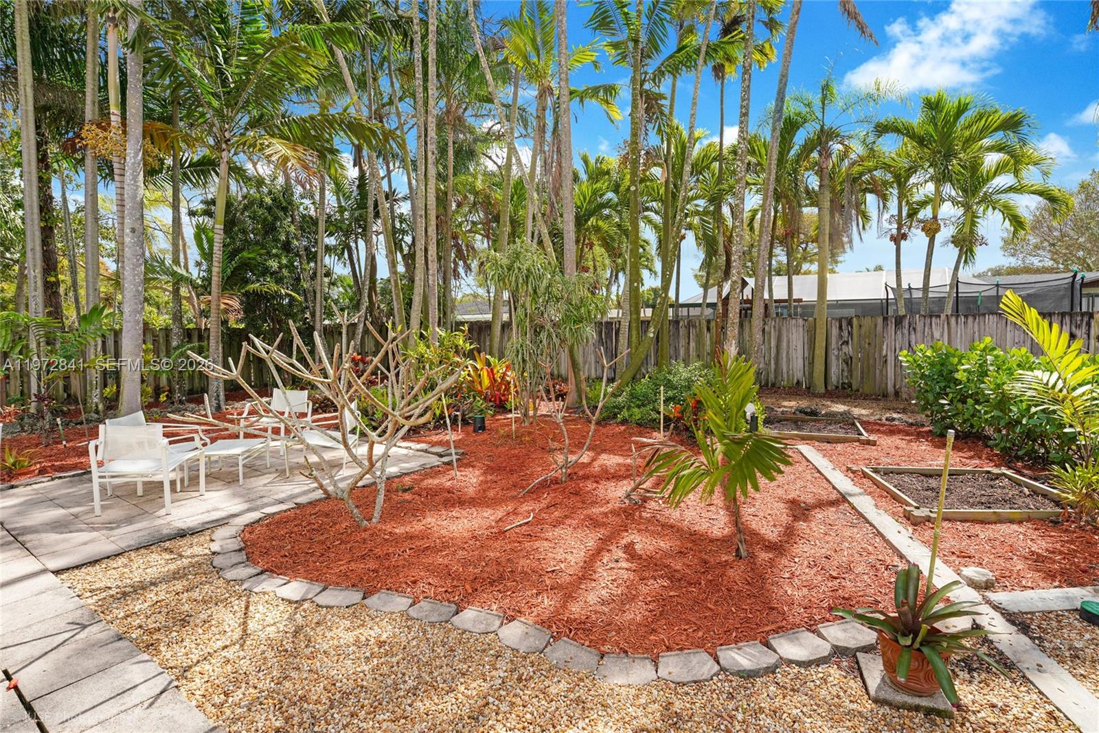 9860 Southwest 122nd Street Miami, FL 33176 - Photo 4 of 27 a view of a yard with plants and large trees