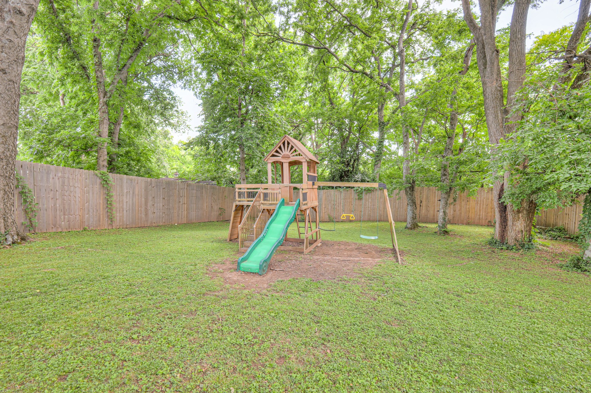 691 Harding Place Nashville, TN 37211 - Photo 44 of 54 a view of a backyard with a slide trees and wooden fence