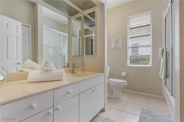 a bathroom with a granite countertop sink a toilet and a mirror