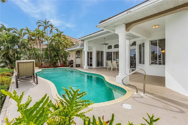 a view of a swimming pool with chair and tables