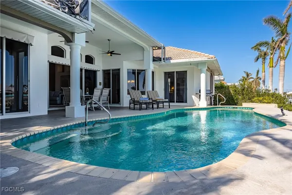 a view of a house with swimming pool and sitting area