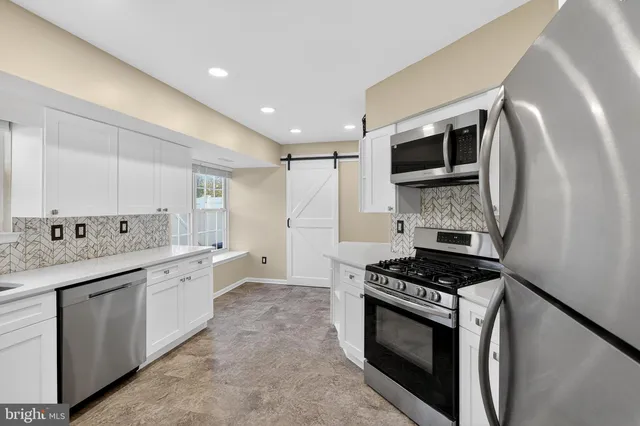 a kitchen with stainless steel appliances a sink stove and cabinets