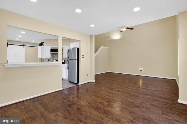 a view of a kitchen with a refrigerator and a stove top oven