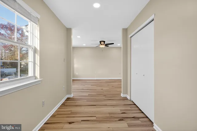 a view of a hallway with wooden floor and windows