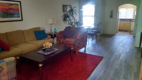 a living room with furniture rug and wooden floor