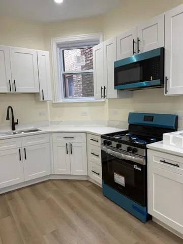 a kitchen with stainless steel appliances granite countertop a sink a stove a microwave and wooden cabinets