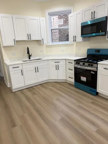 a kitchen with a stove a sink and a microwave