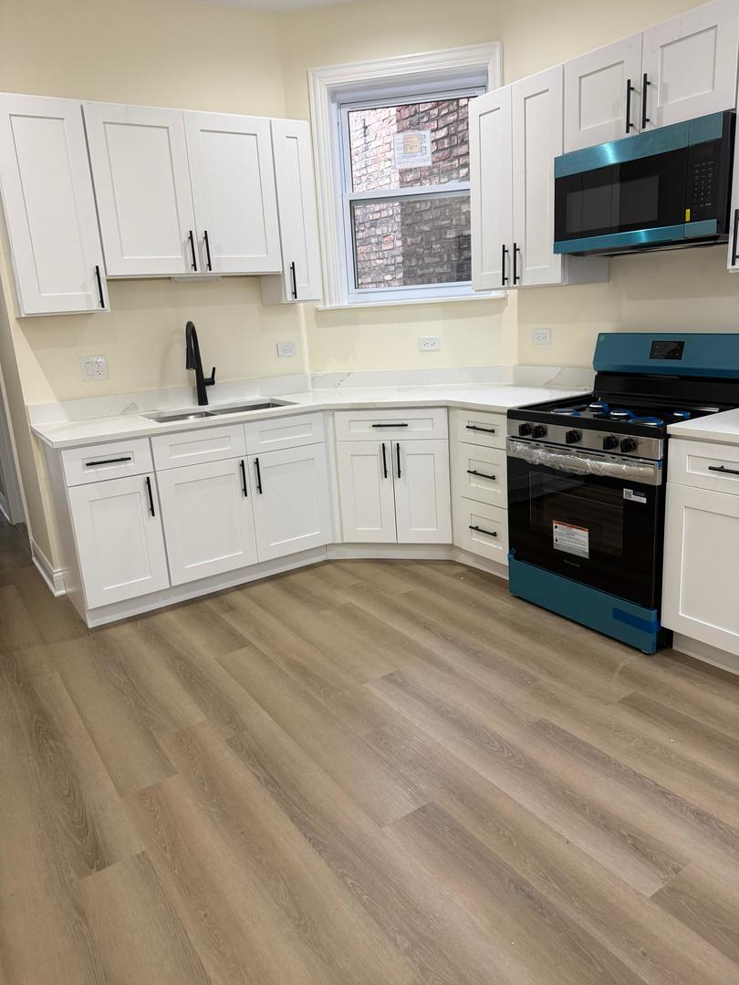 5617 South Laflin Street, Unit 2 Chicago, IL 60636 - Photo 9 of 9 a kitchen with a stove a sink and a microwave