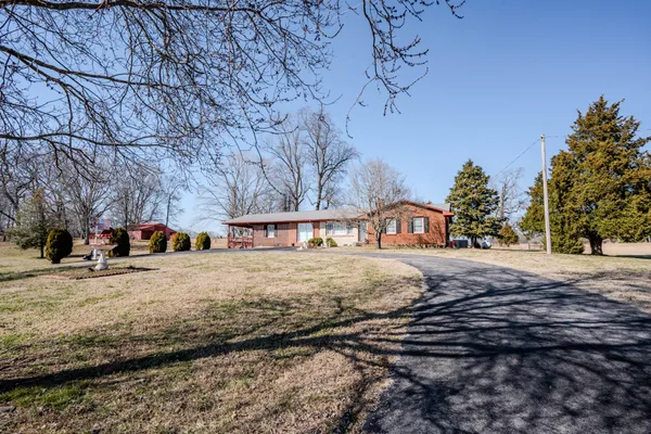 a front view of a house with a yard covered in snow