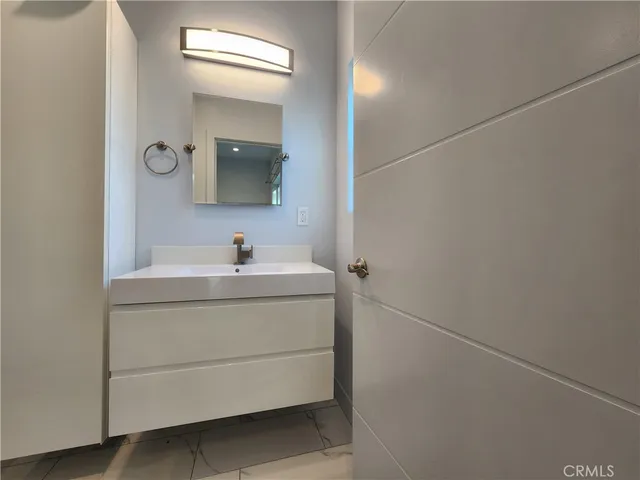 a bathroom with a sink vanity and mirror