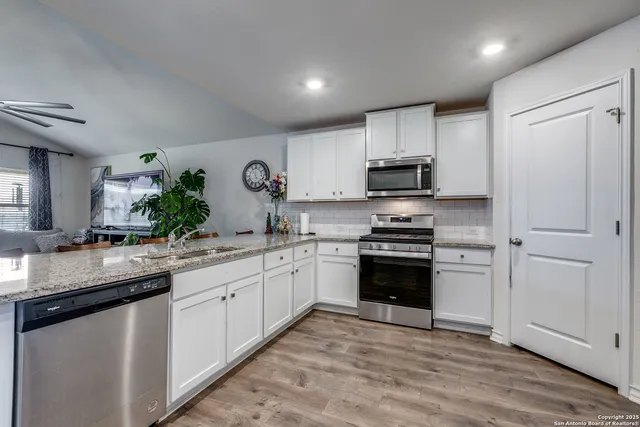 a kitchen with granite countertop a stove sink and cabinets
