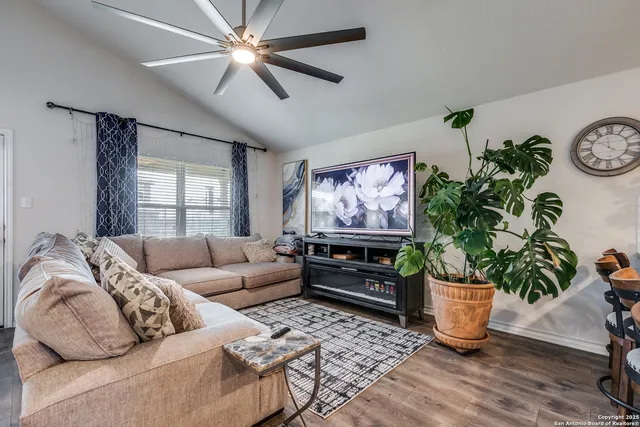 a living room with furniture a chandelier and a potted plant