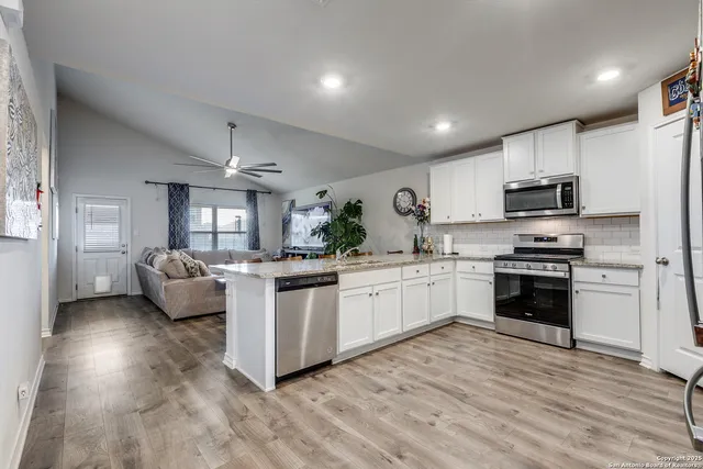 a kitchen with granite countertop a sink cabinets and stainless steel appliances