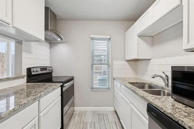 a kitchen with granite countertop a sink stainless steel appliances and counter space