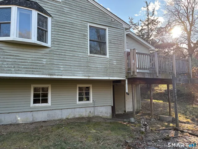 a view of a house with a yard and large tree