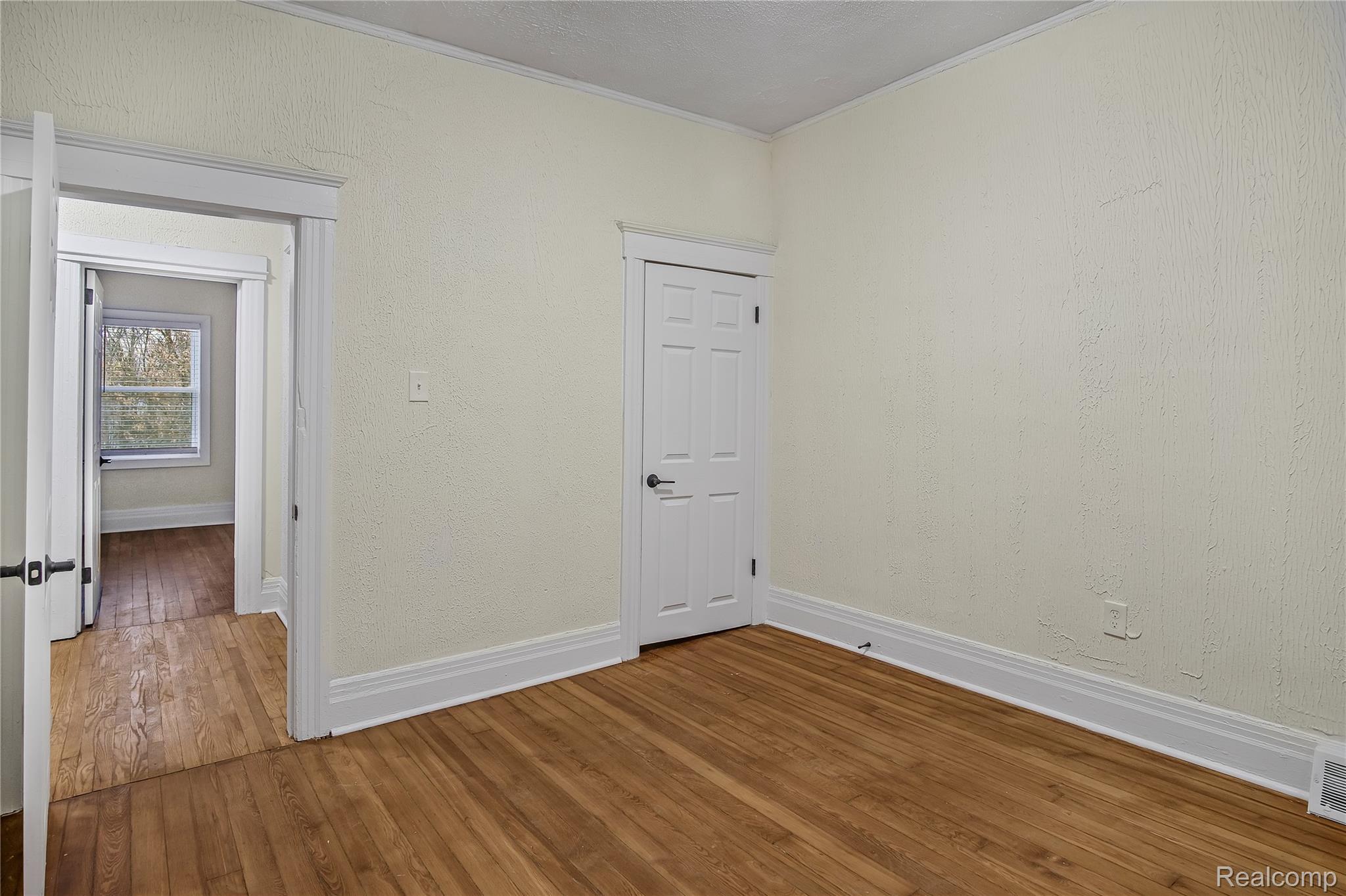 427 Melbourne Street Detroit, MI 48202 - Photo 12 of 29 Unfurnished room with hardwood / wood-style flooring, crown molding, and a textured wall