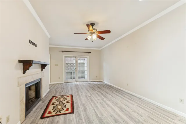 an empty room with fireplace fan and windows