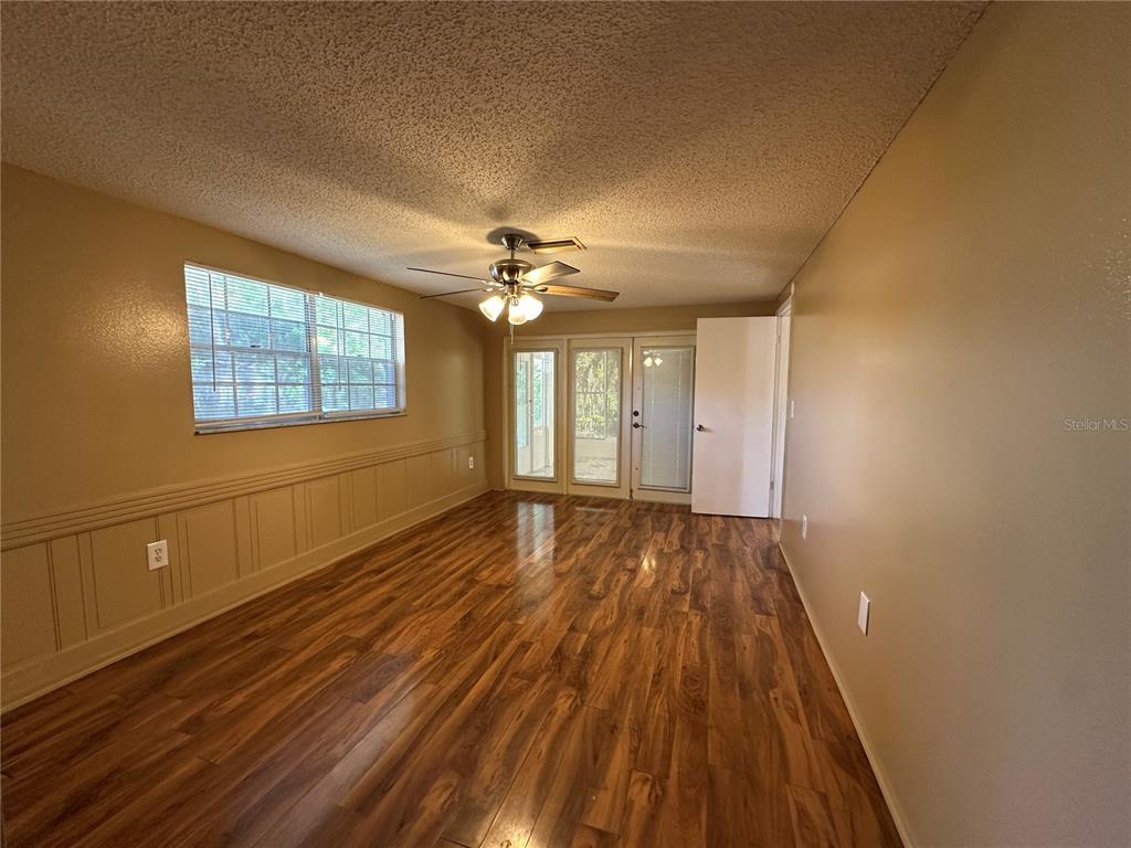8809 Avondale Lane Hudson, FL 34667 - Photo 13 of 46 a view of an empty room with wooden floor and a window