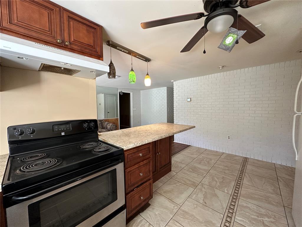8809 Avondale Lane Hudson, FL 34667 - Photo 19 of 46 a kitchen with a stove cabinets and wooden floor