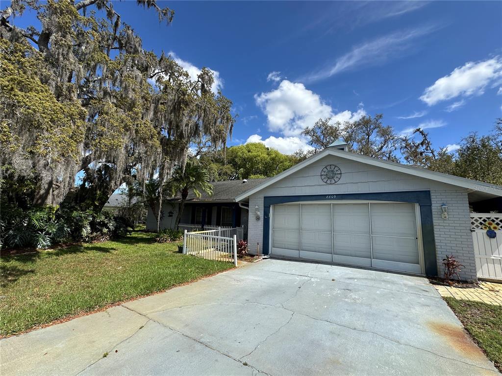 8809 Avondale Lane Hudson, FL 34667 - Photo 2 of 46 front view of a house with a yard and garage