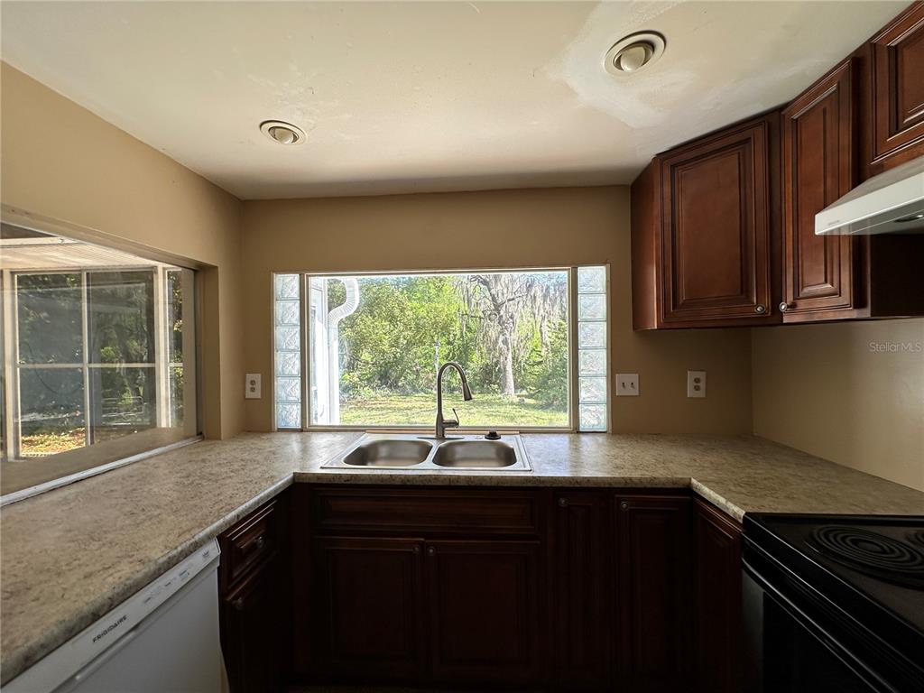 8809 Avondale Lane Hudson, FL 34667 - Photo 24 of 46 a kitchen with granite countertop a stove a sink and a microwave