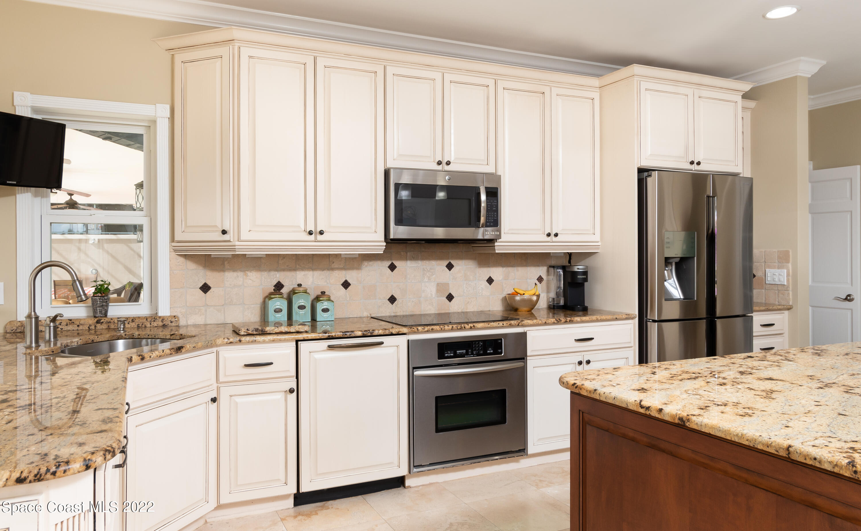 870 Kerry Downs Circle Melbourne, FL 32940 - Photo 11 of 41 a kitchen with granite countertop white cabinets and stainless steel appliances