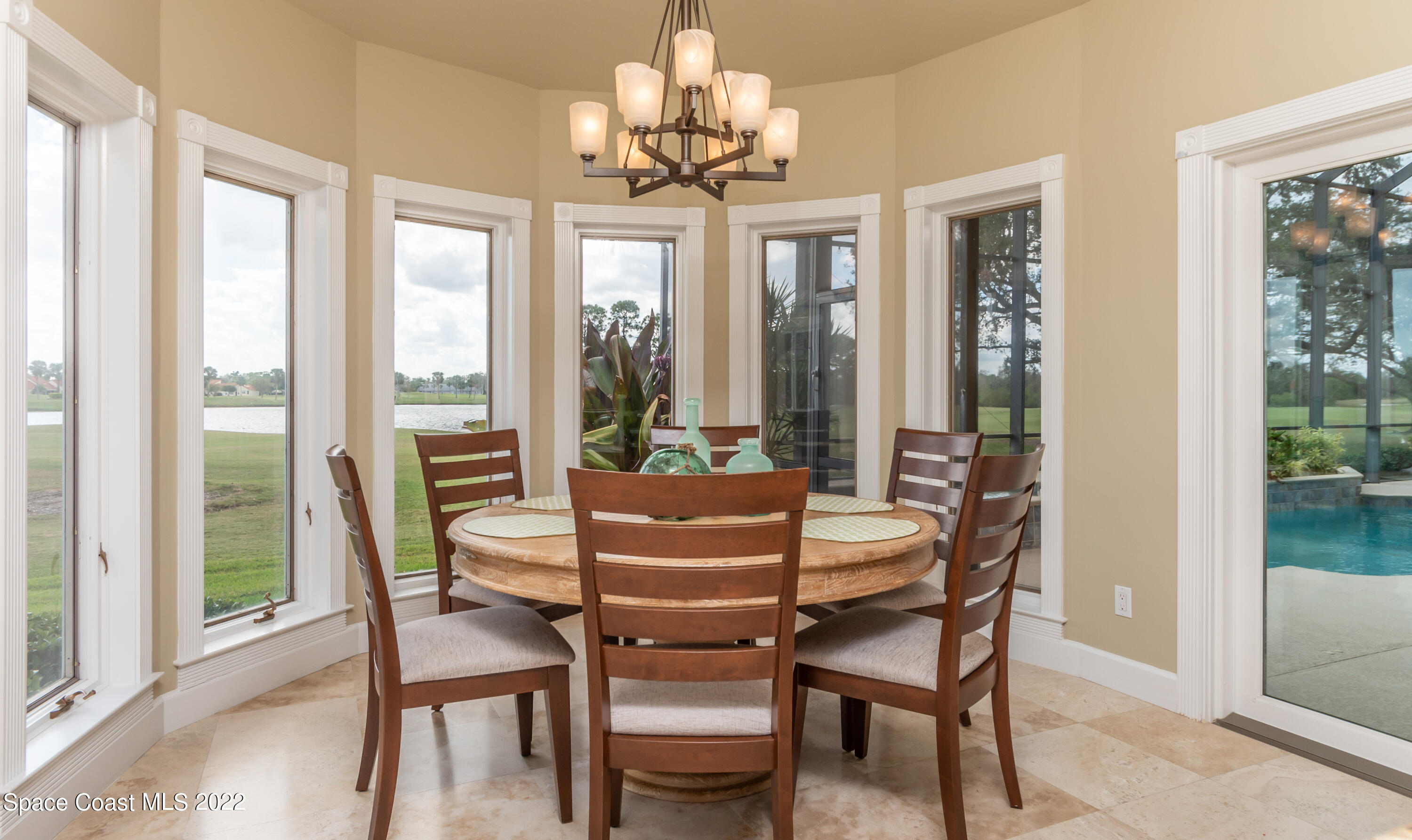 870 Kerry Downs Circle Melbourne, FL 32940 - Photo 12 of 41 a dining room with furniture a chandelier and wooden floor