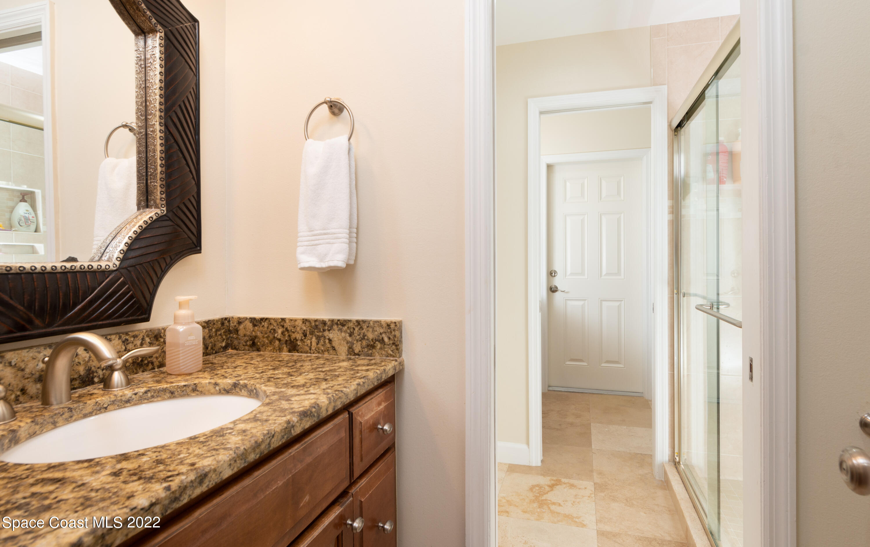 870 Kerry Downs Circle Melbourne, FL 32940 - Photo 24 of 41 a bathroom with a granite countertop sink and a mirror
