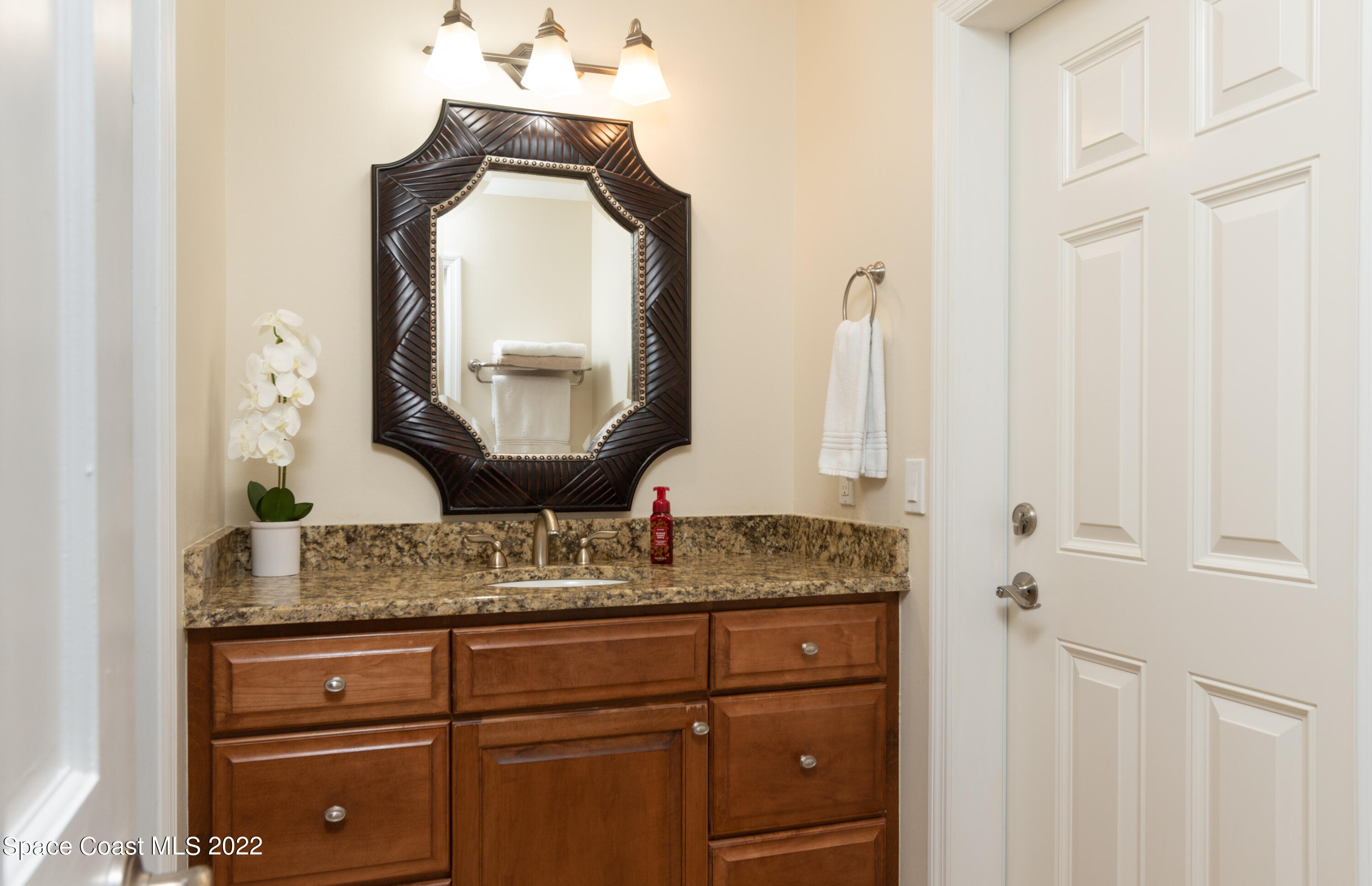 870 Kerry Downs Circle Melbourne, FL 32940 - Photo 25 of 41 a bathroom with a granite countertop sink and a mirror
