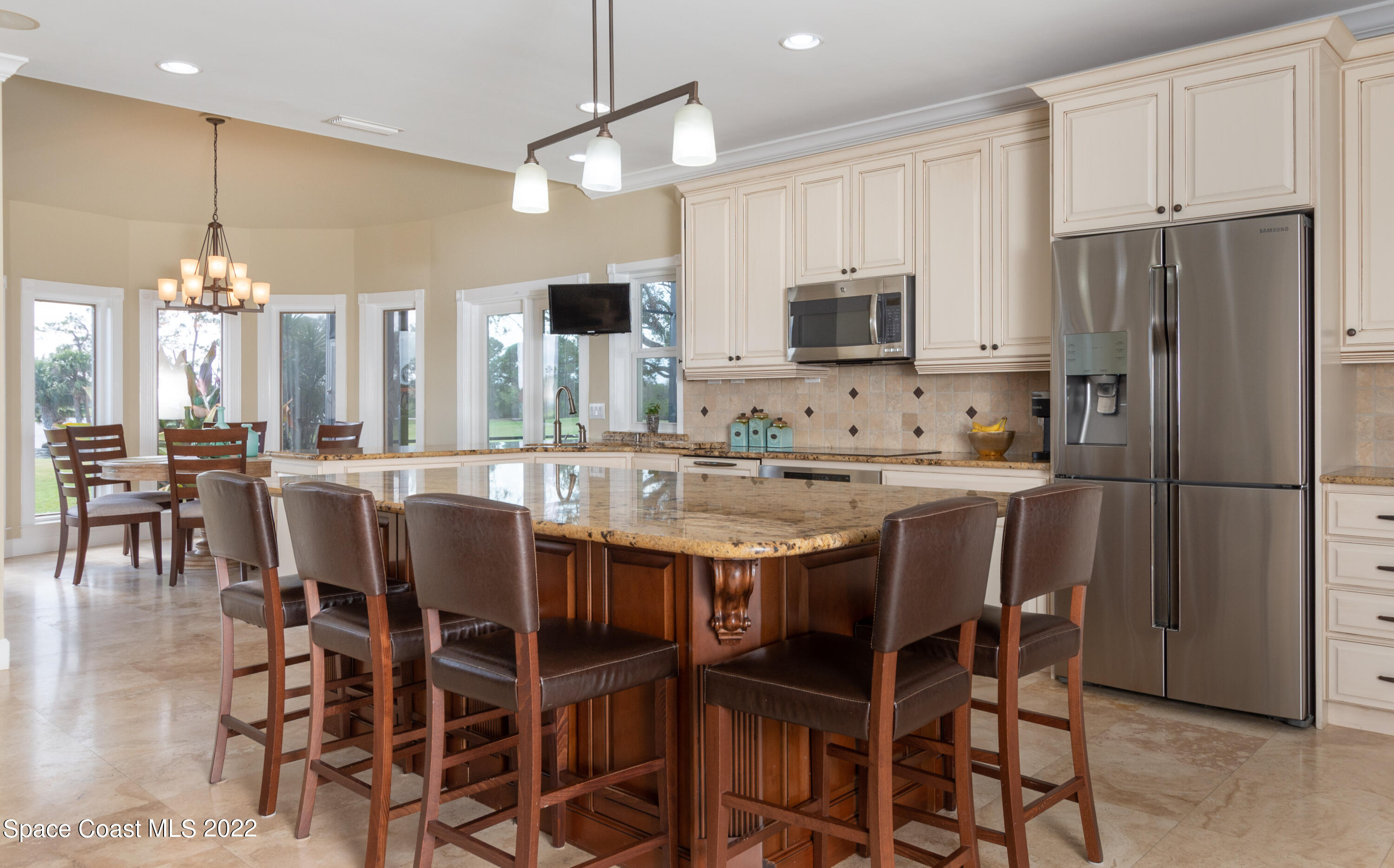 870 Kerry Downs Circle Melbourne, FL 32940 - Photo 10 of 41 a kitchen with stainless steel appliances kitchen island granite countertop a dining table chairs and a refrigerator