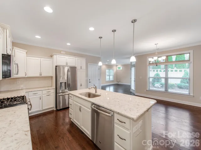 a open kitchen with stainless steel appliances granite countertop a sink a stove a refrigerator and island with wooden floor