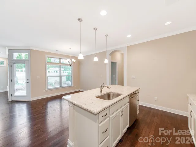 a open kitchen with a sink and wooden floor