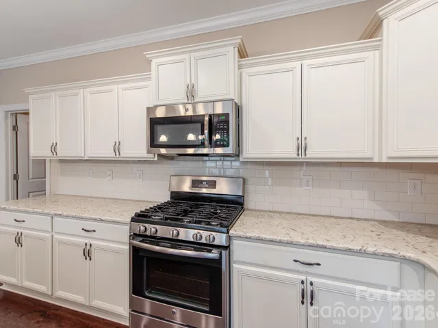 a kitchen with white cabinets and stainless steel appliances