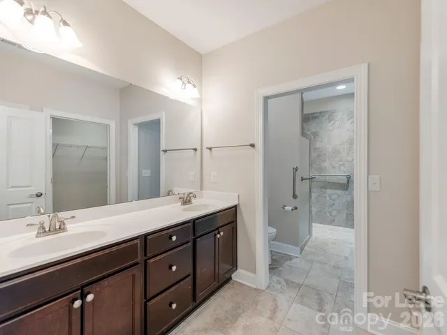 a spacious bathroom with a granite countertop sink a toilet and shower